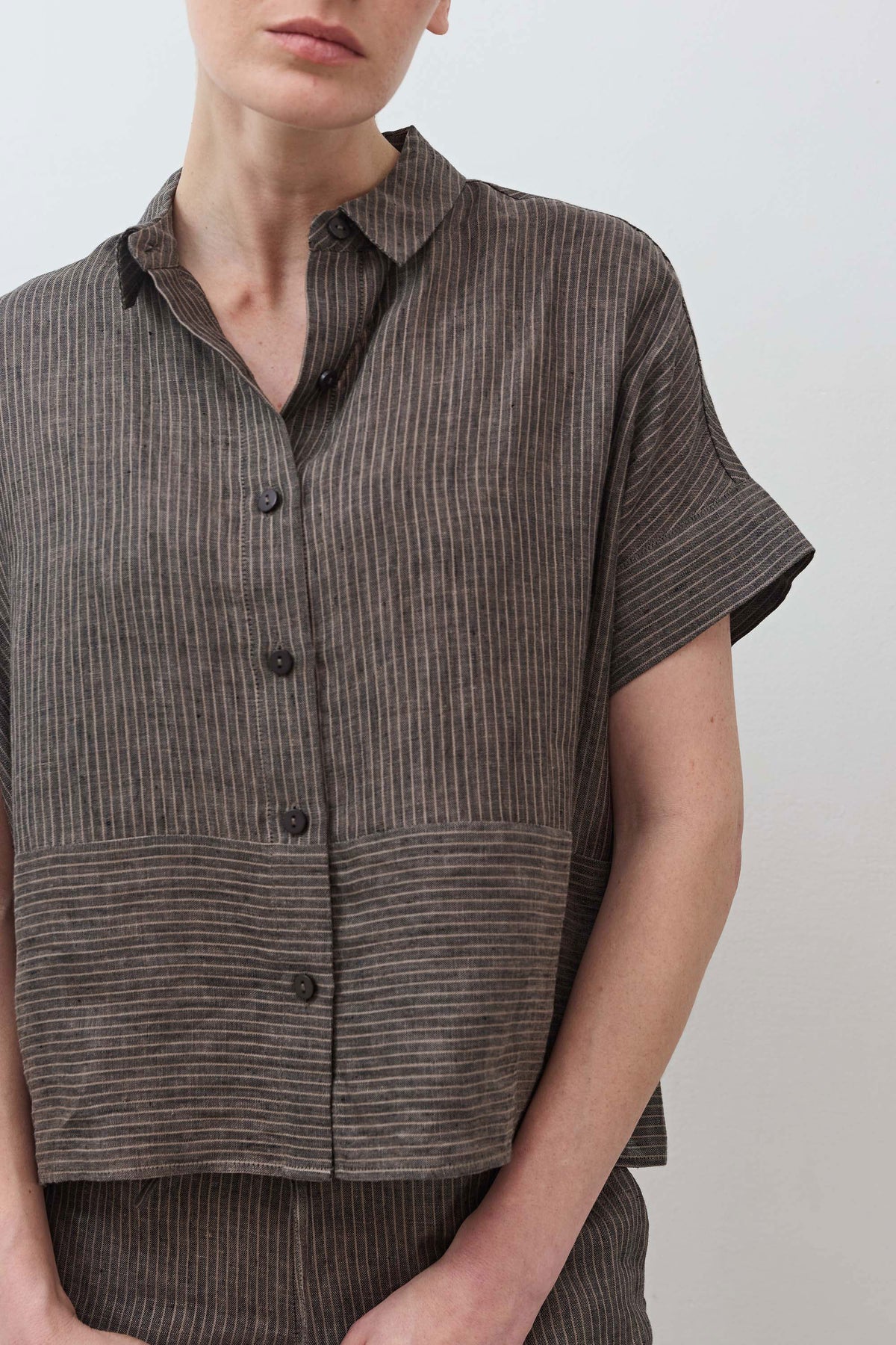 Close-up of charcoal linen button-front blouse with short sleeves and pointed collar