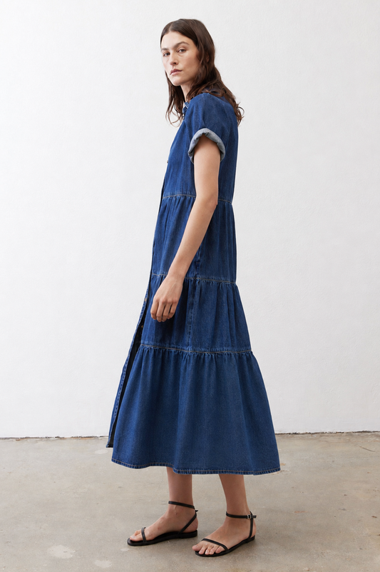 Medium-wash denim midi dress with short sleeves, tiered skirt, and button front