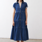 Medium-wash denim midi dress with short sleeves, collared neckline, and tiered skirt