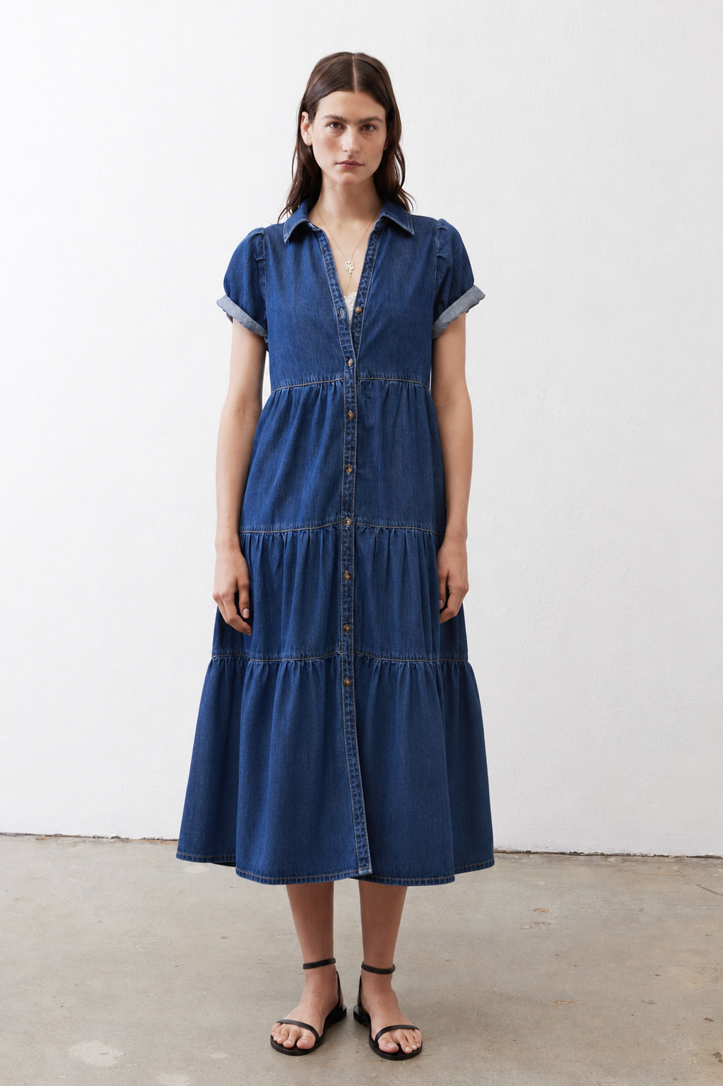 Medium-wash denim midi dress with short sleeves, collared neckline, and tiered skirt