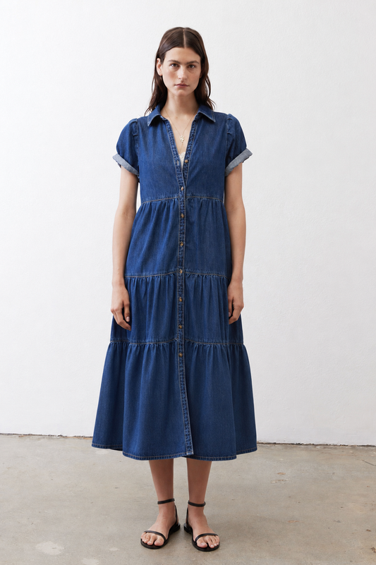 Medium-wash denim midi dress with short sleeves, collared neckline, and tiered skirt