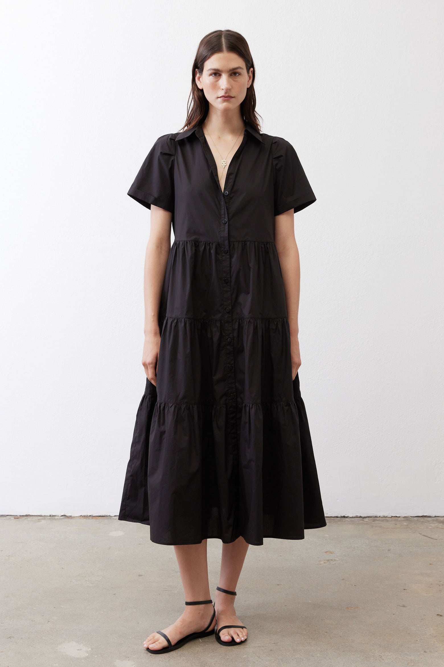 Black long poplin dress with short sleeves, V-neck, and tiered silhouette