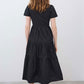 Back view of black long poplin dress with tiered skirt and short sleeves