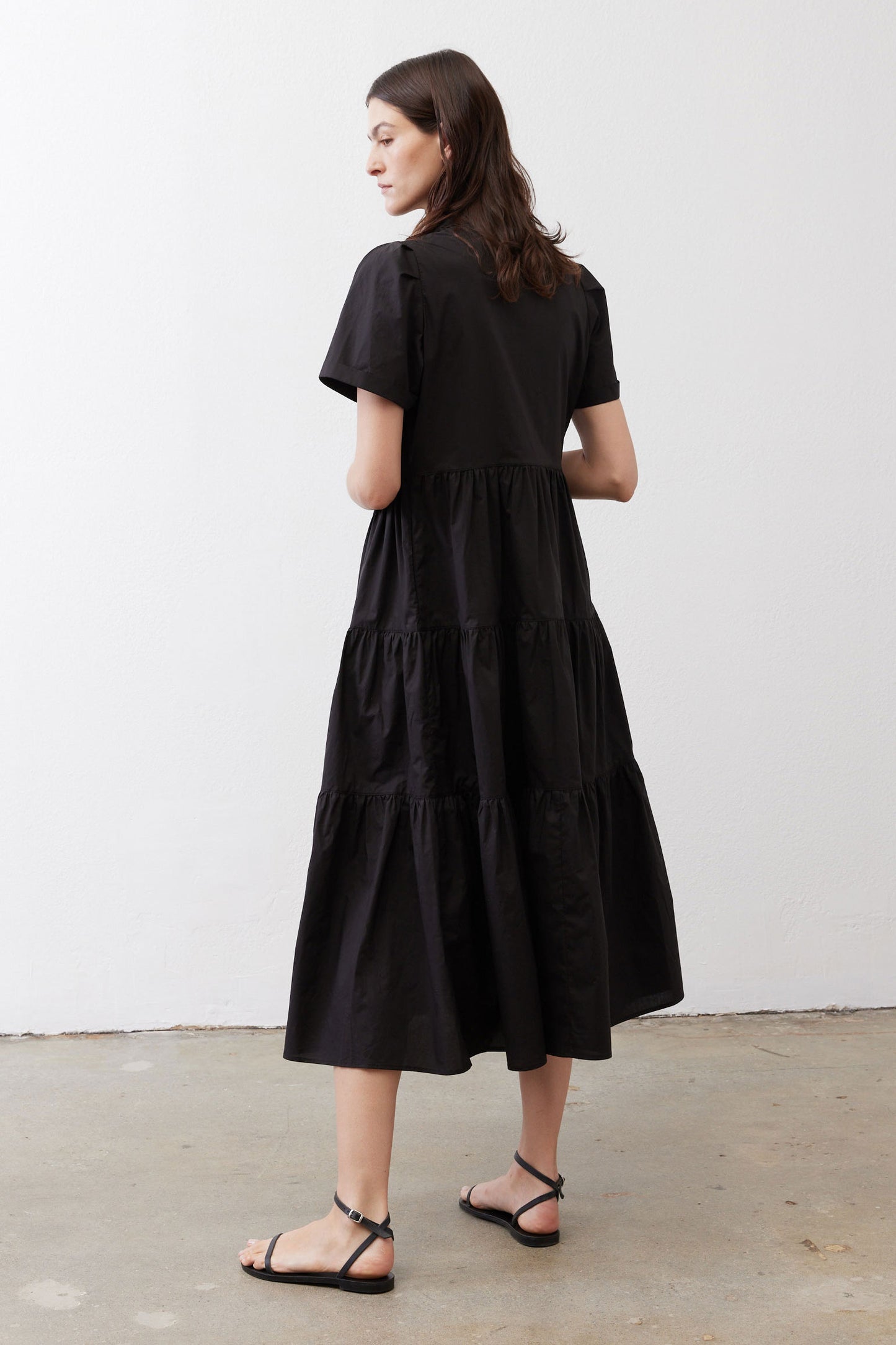 Black long dress from back view with tiered skirt and short sleeves