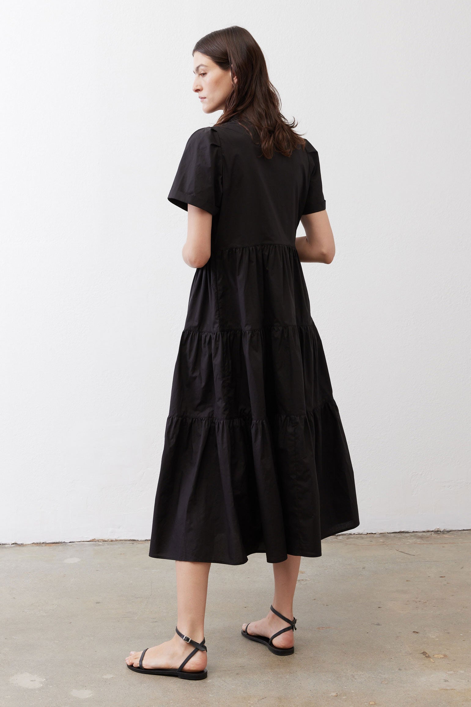 Black long dress from back view with tiered skirt and short sleeves