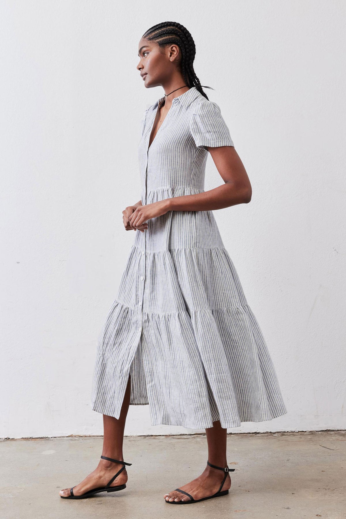 Side view of long linen dress with white and blue stripes, short sleeves, tiered skirt