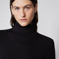 Close-up of black high-neck turtleneck sweater in brushed ribbed knit