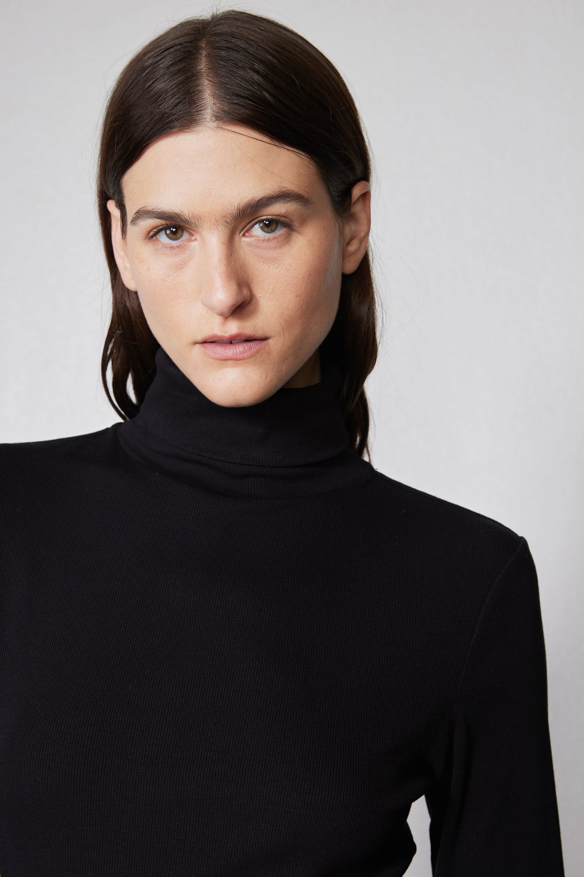 Close-up of black high-neck turtleneck sweater in brushed ribbed knit