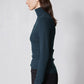 Forest green ribbed turtleneck long-sleeve top, side view with high collar