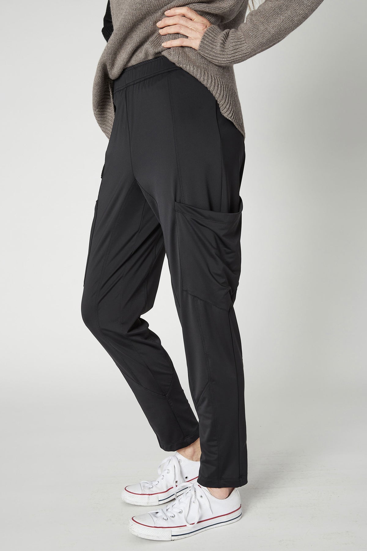 Black cargo pants with side cargo pocket and relaxed taper, ankle cuffs.