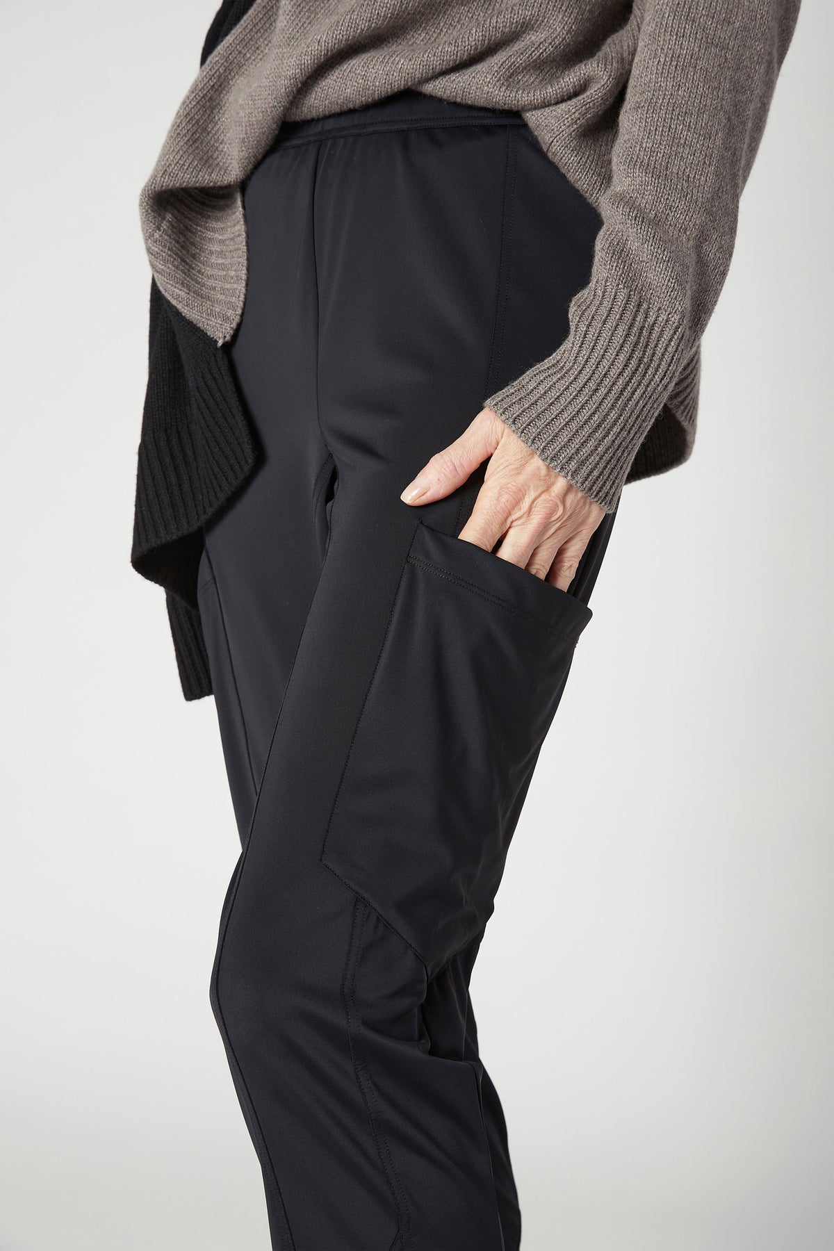 Black cargo pants detail: elastic waist and side cargo pocket with flap.