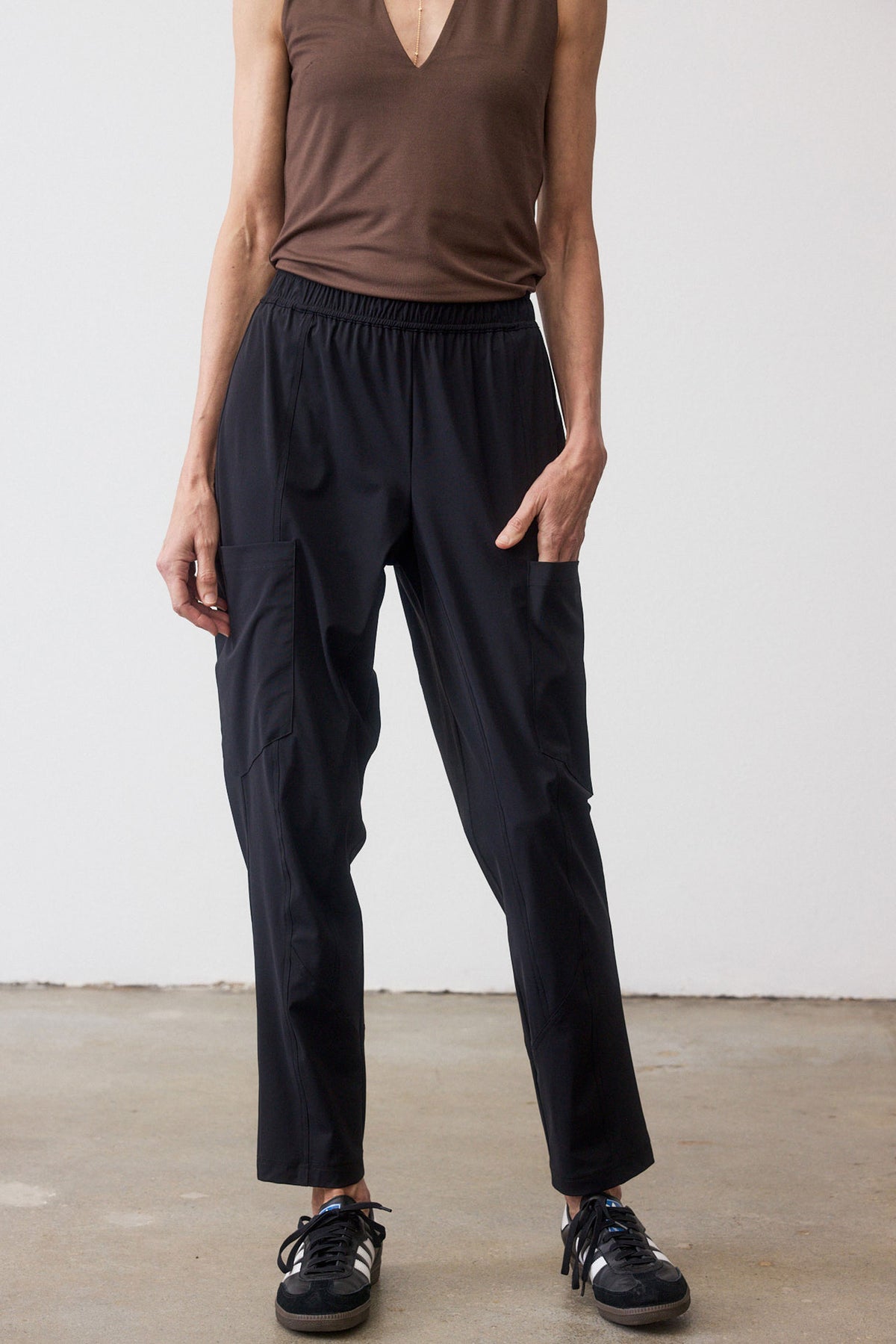 Black cargo pants with elastic waist and tapered legs, side cargo pockets.