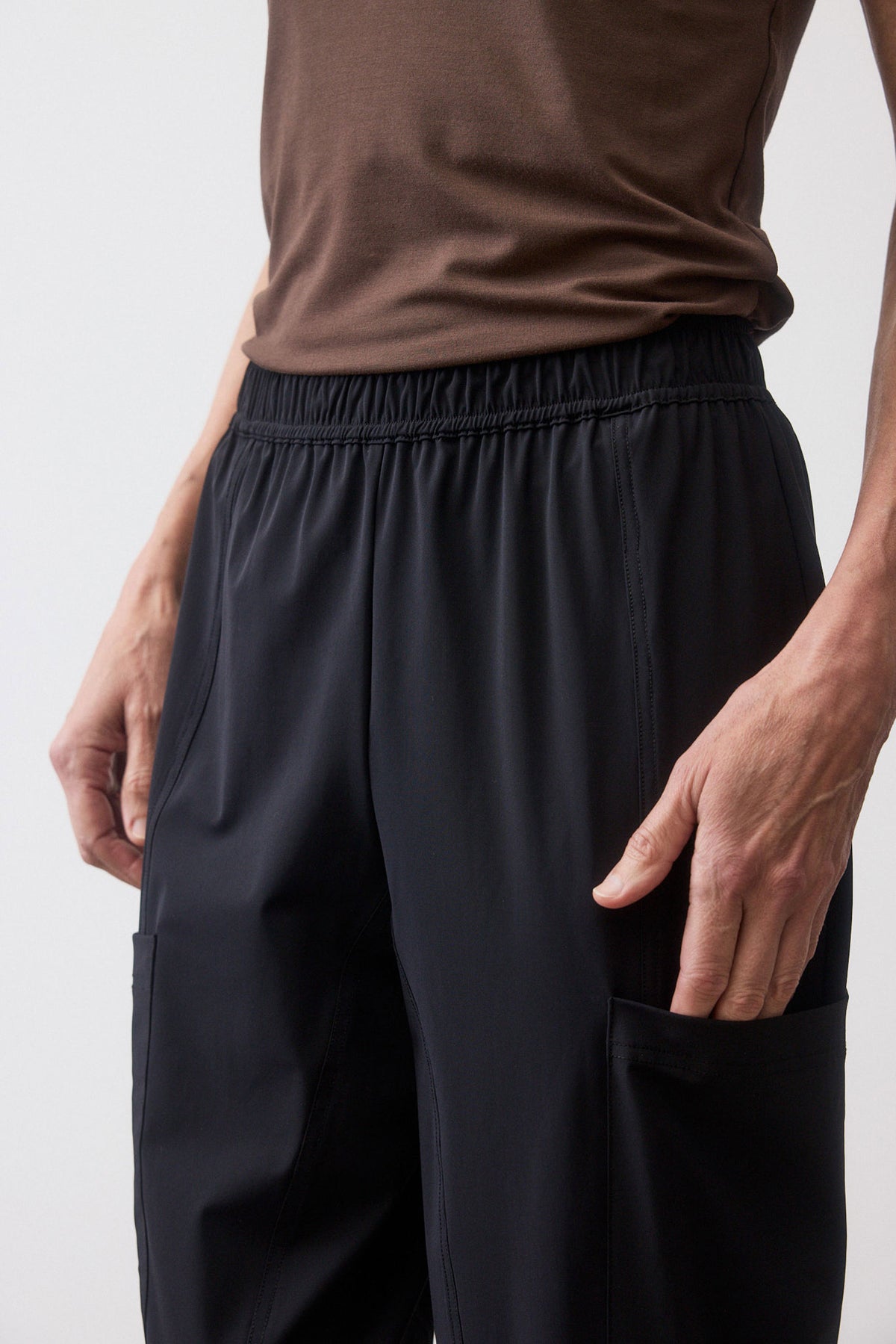 Black cargo pants with elastic waistband, gathered front, and side pockets.