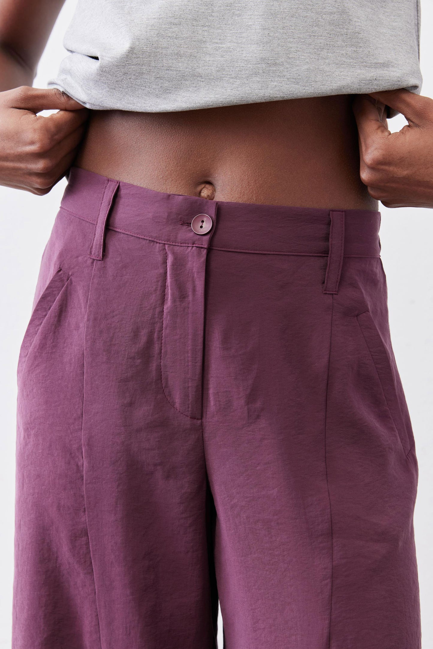 Deep purple pants with button closure, belt loops, and side pocket