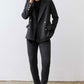 Charcoal herringbone double-breasted blazer on model, gold buttons and front pockets