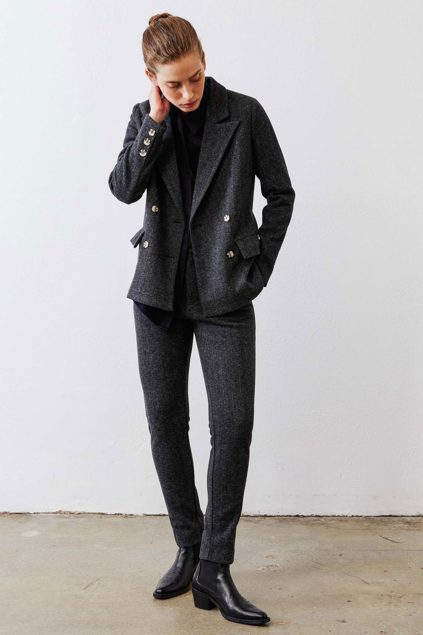 Charcoal herringbone double-breasted blazer on model, gold buttons and front pockets