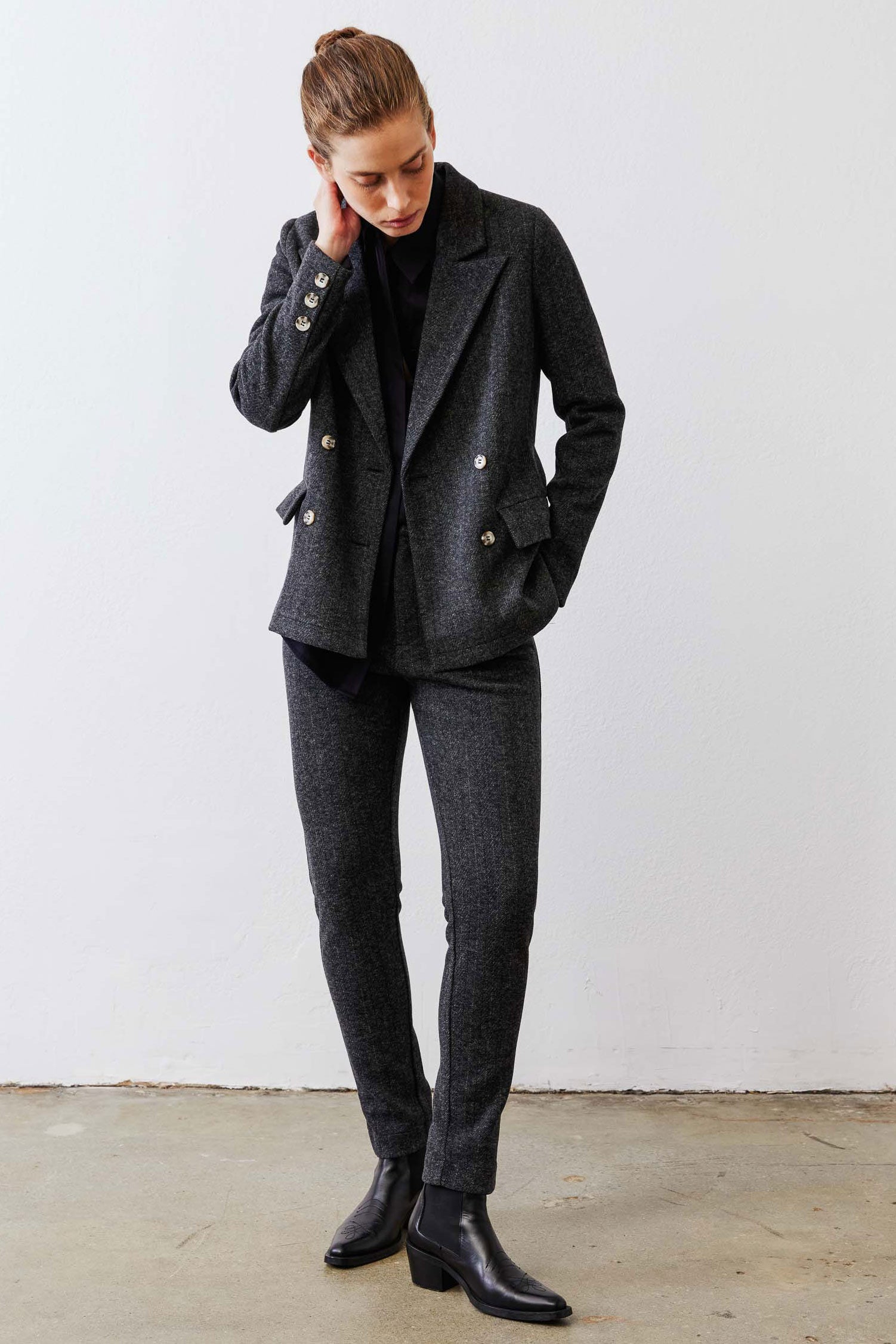 Charcoal herringbone double-breasted blazer on model, gold buttons and front pockets