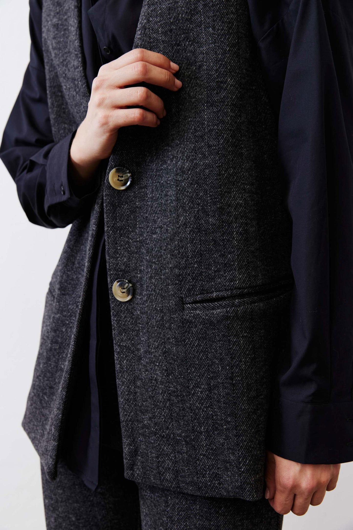 Charcoal herringbone vest front with gold buttons and welt pocket