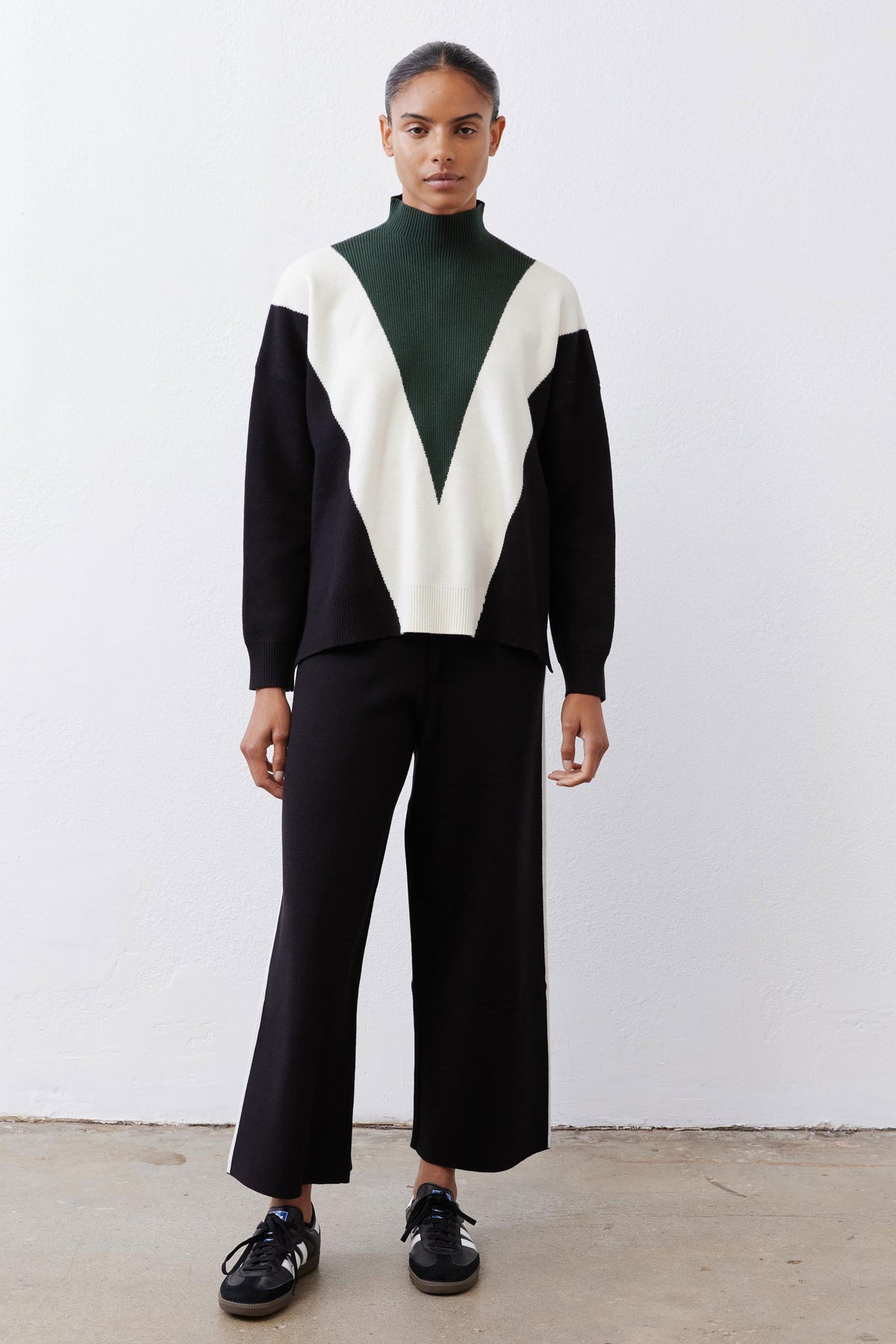 Chevron colorblock turtleneck sweater in forest green, cream, and black with relaxed fit.