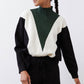 Turtleneck knit sweater with chevron colorblocking in forest green, cream, and black.