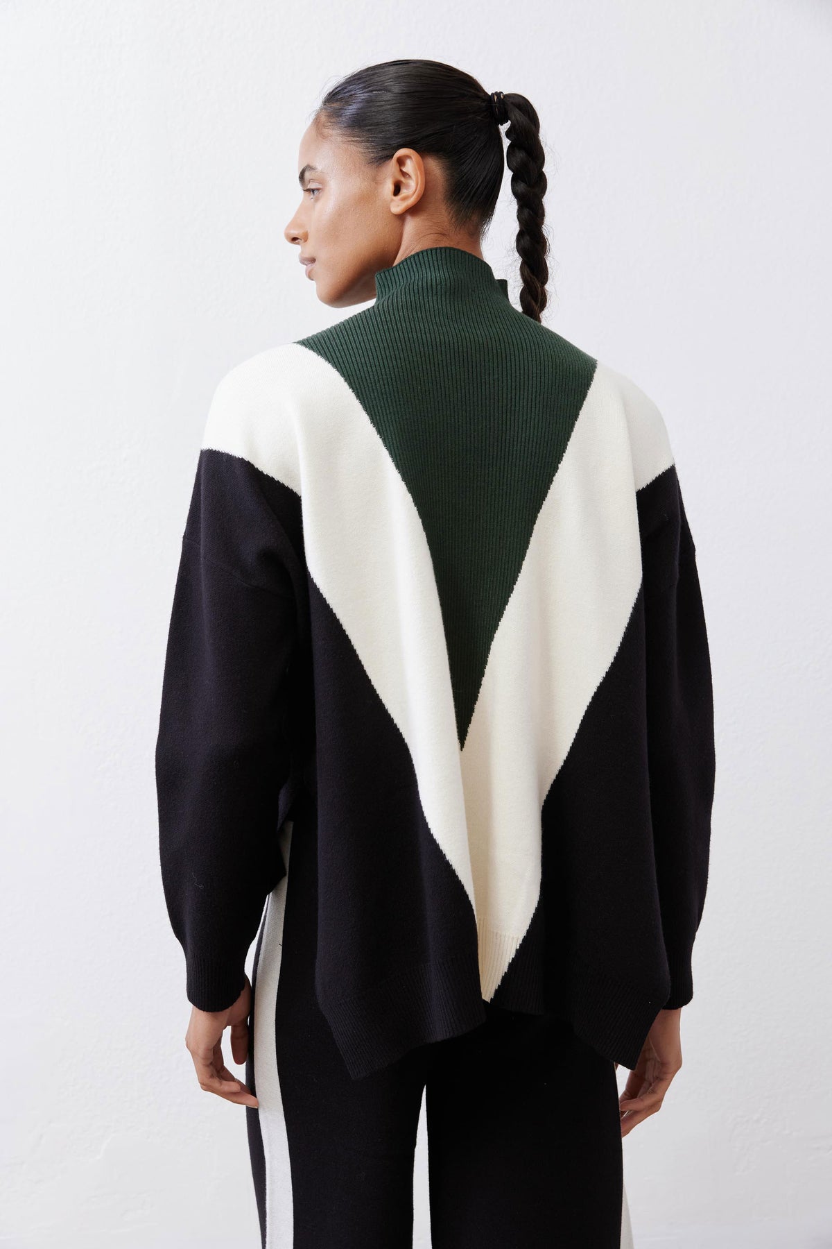 Chevron colorblock knit sweater with turtleneck, forest green, cream, and black panels.