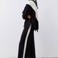 Black wide-leg lounge pants with ivory side stripe and drawstring waist, side view