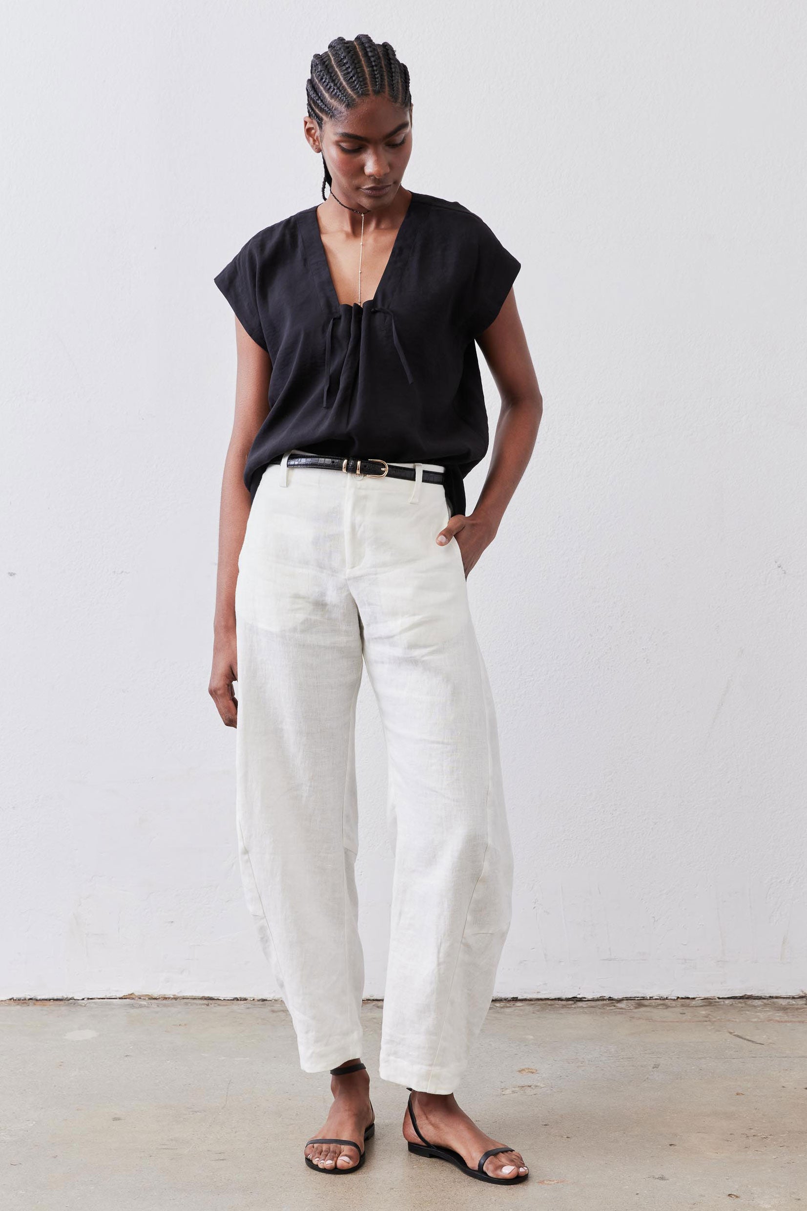 Black cinched V-neck poplin top with short sleeves, front full-length view