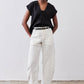 Black cinched-neck poplin top with short sleeves and gathered front, worn tucked into pants