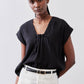 Black poplin top with cinched V neckline and short sleeves, draped gathered front
