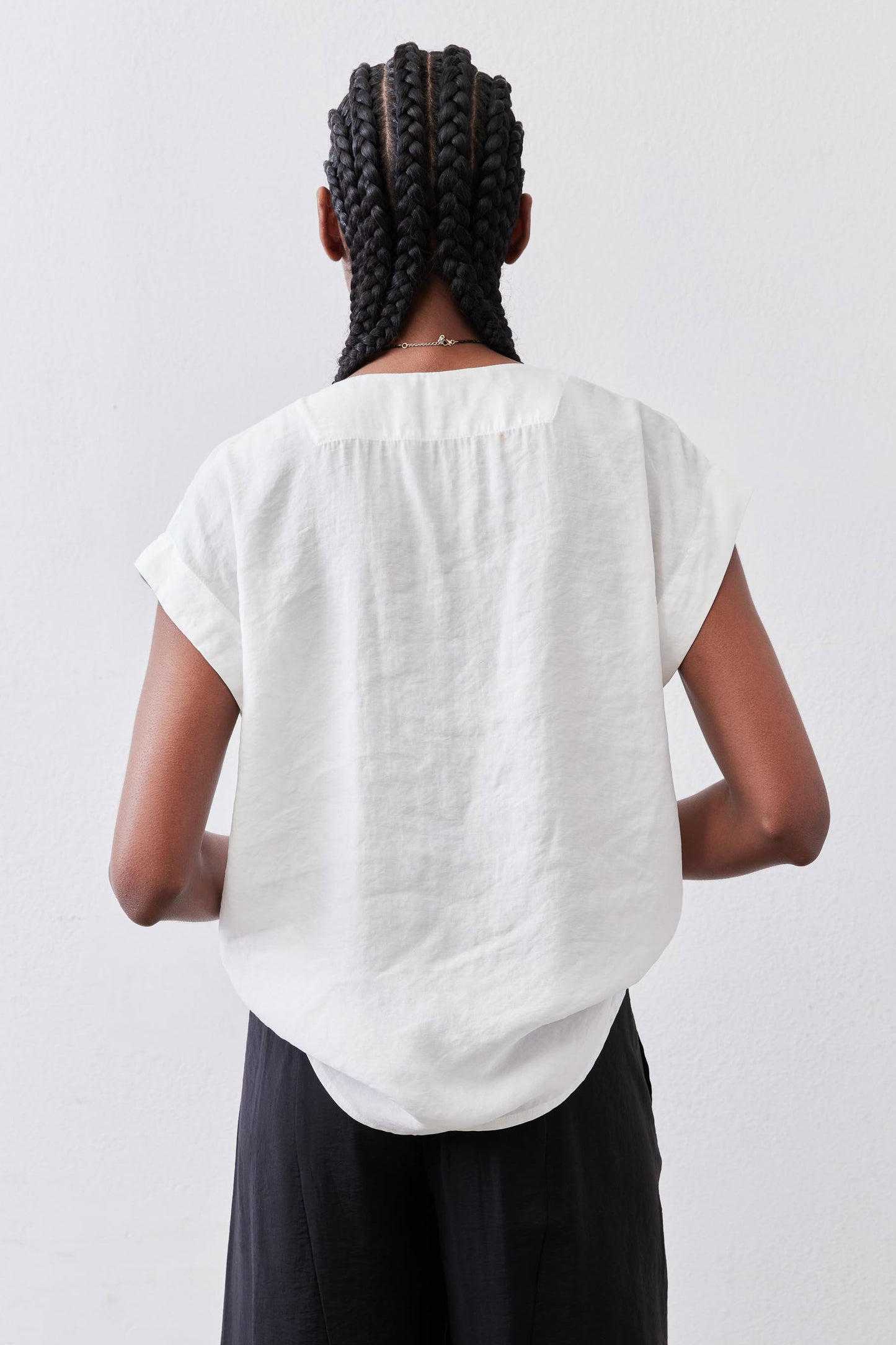 Back view: white poplin top with short sleeves and relaxed fit