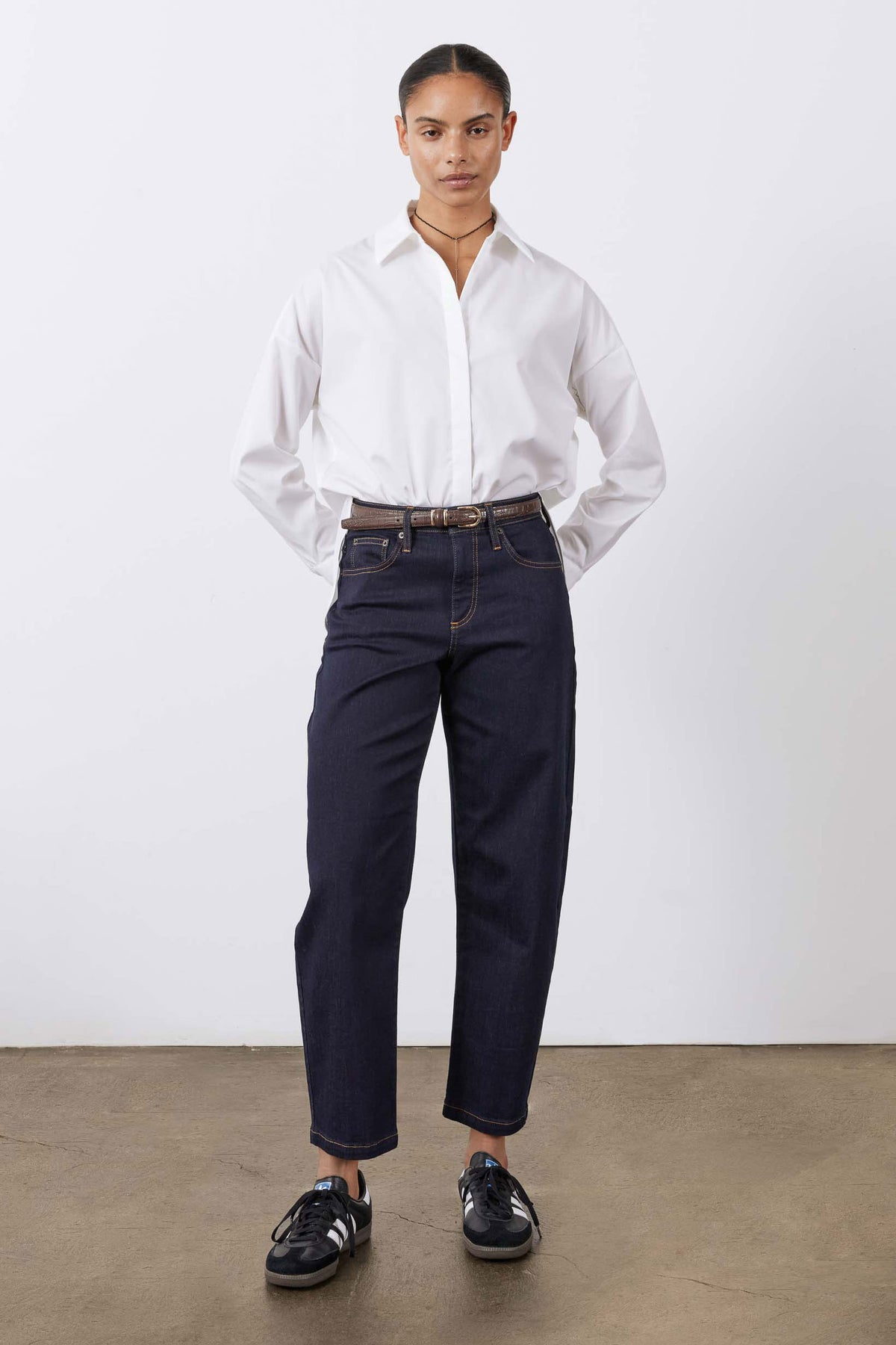 Petite dark wash barrel leg jeans on model, full-length front view
