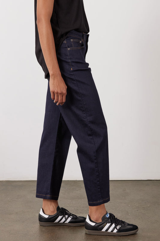 Dark wash barrel-leg jeans, side view, button waist, belt loops and front pockets.