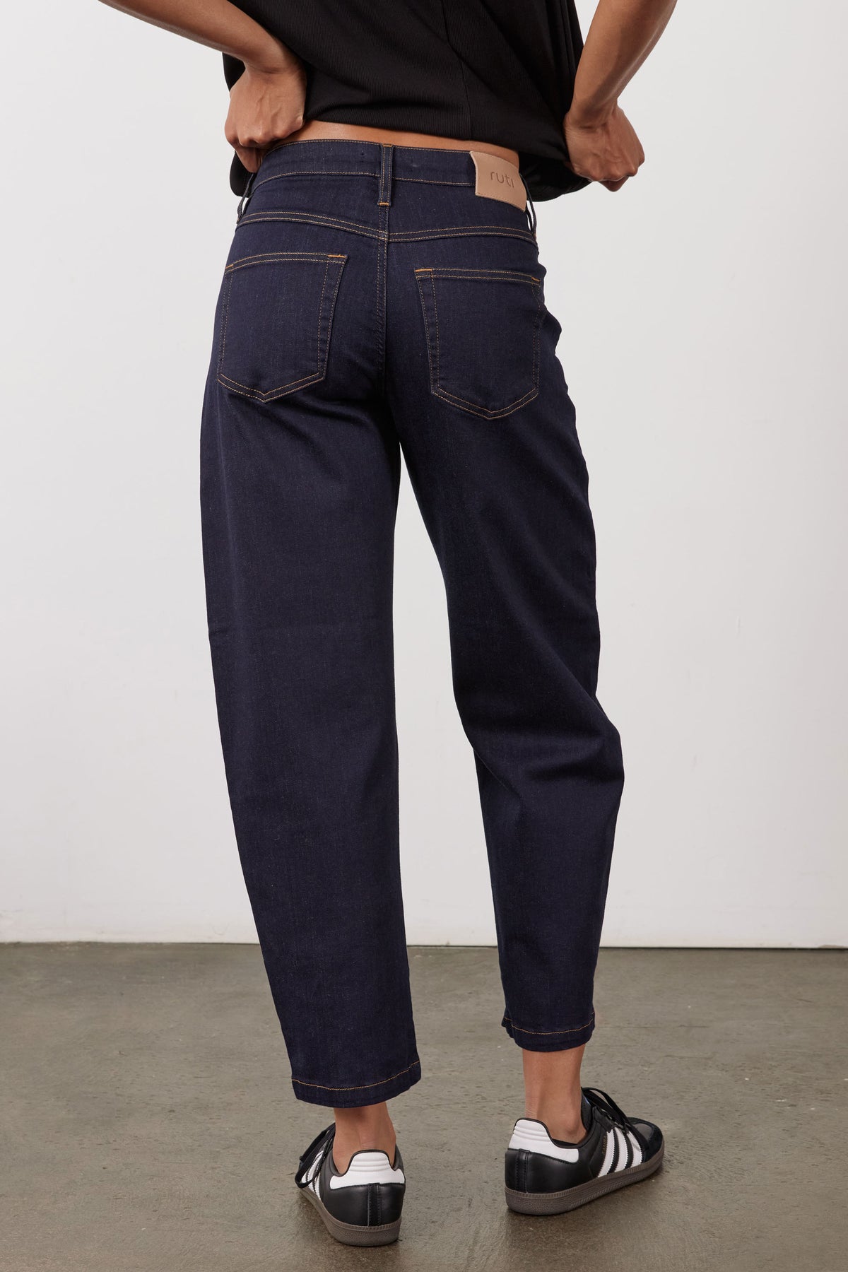 Petite dark wash barrel leg jeans, back view with rear pockets and tapered cuffs