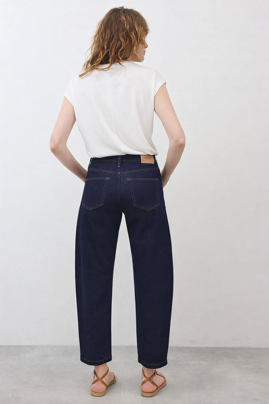 Dark wash barrel-leg jeans, back view, full-length barrel silhouette, belt loops and rear pockets.