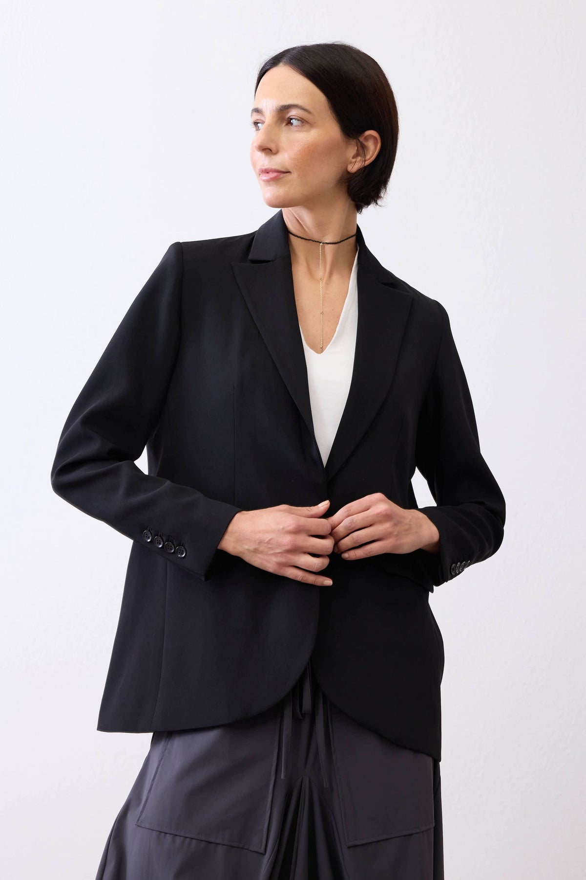 Classic black blazer with notch lapels and long sleeves, worn and buttoned at center