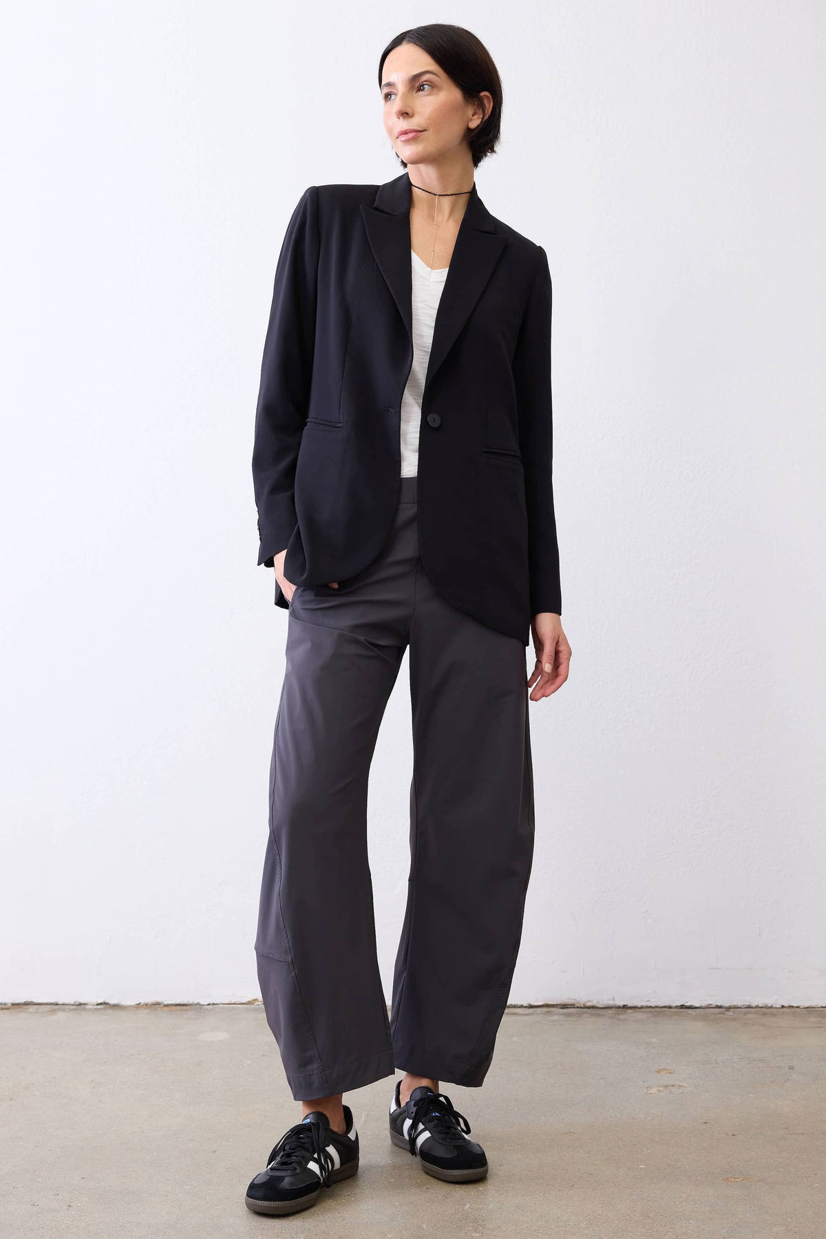 Classic black blazer with notch lapels, worn with dark pants and black sneakers