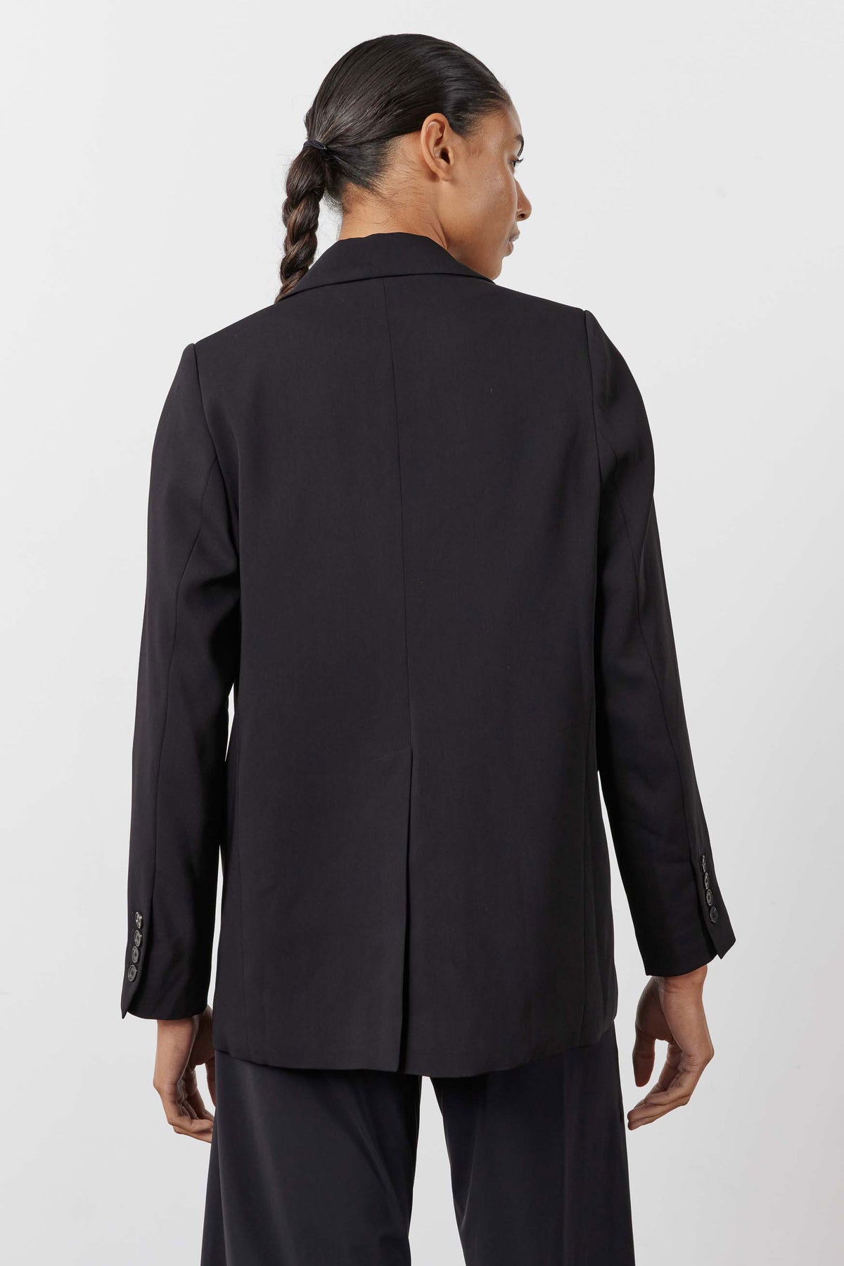 Black blazer back view with center seam and tailored shoulder yoke