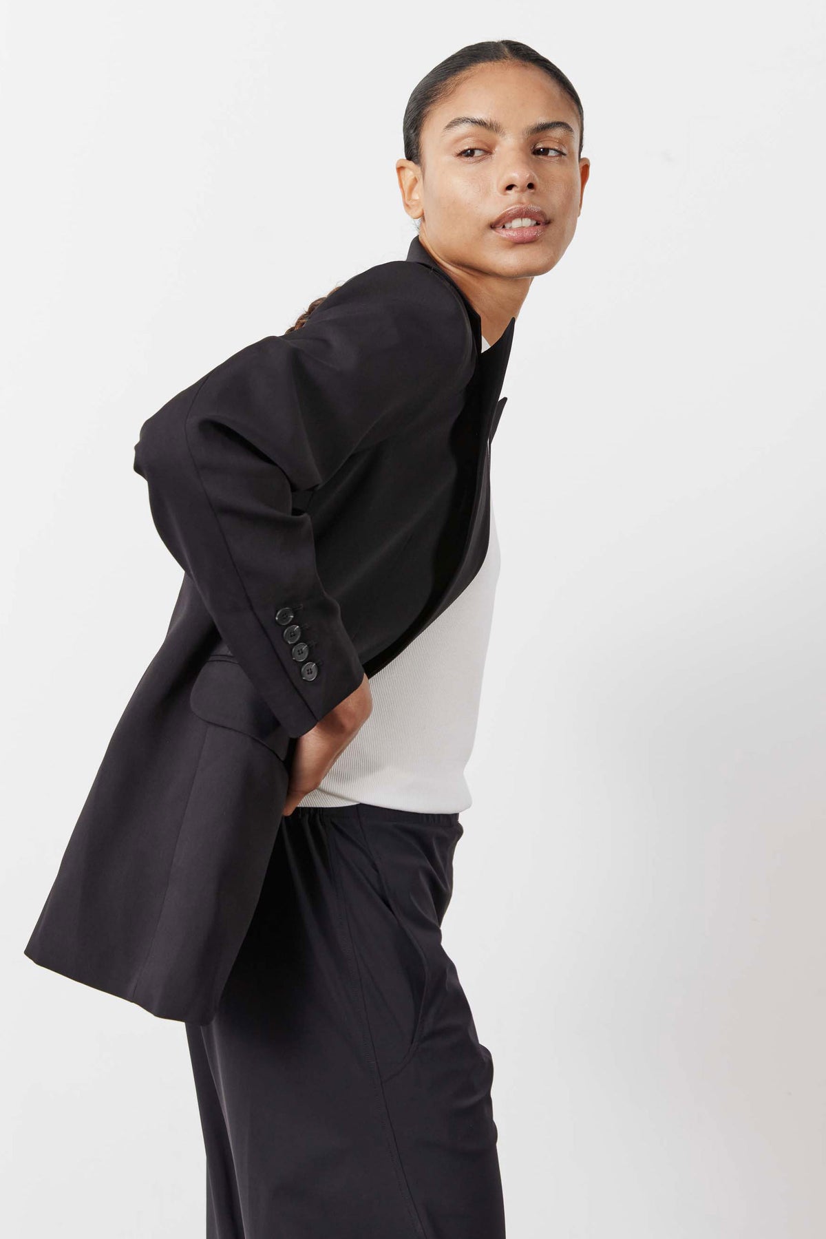 Black blazer with wide cuff buttons, styled with matching tailored pants