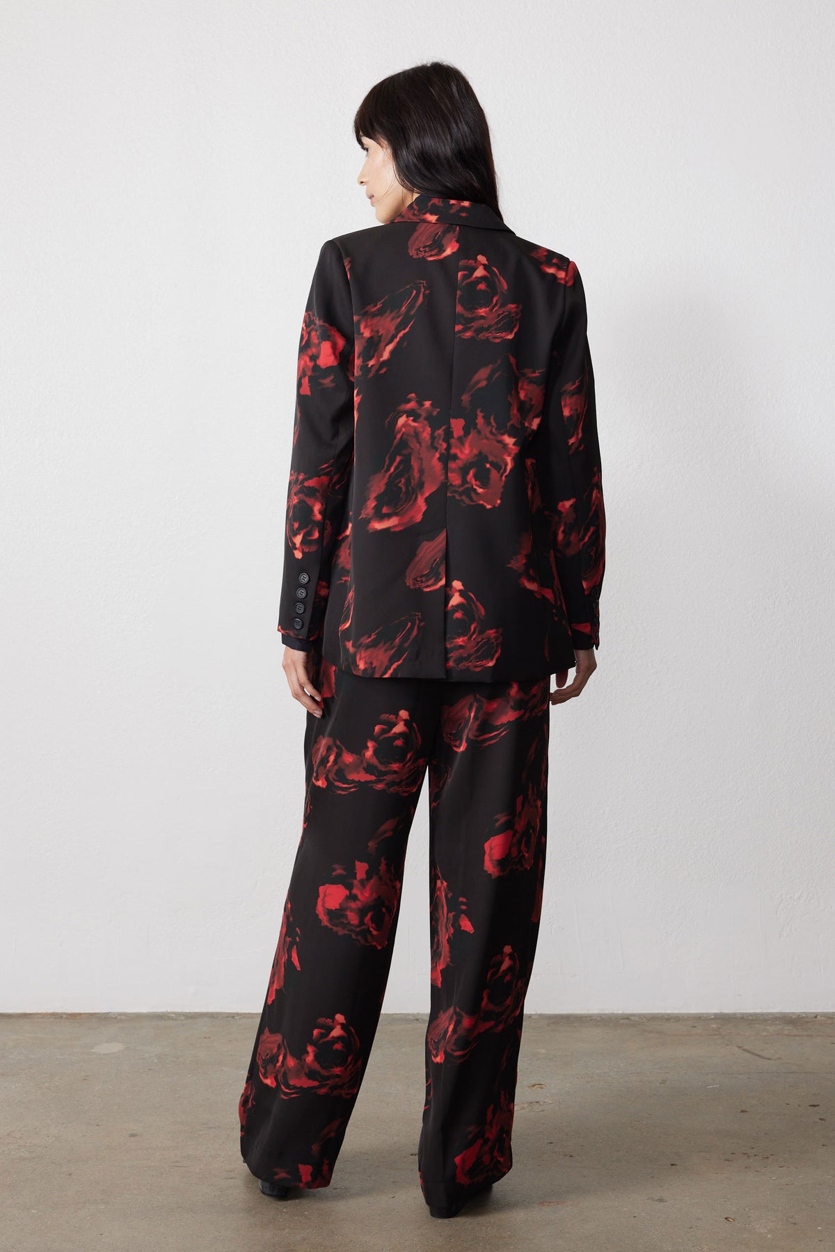 Back view of black blazer with red rose print and long sleeves