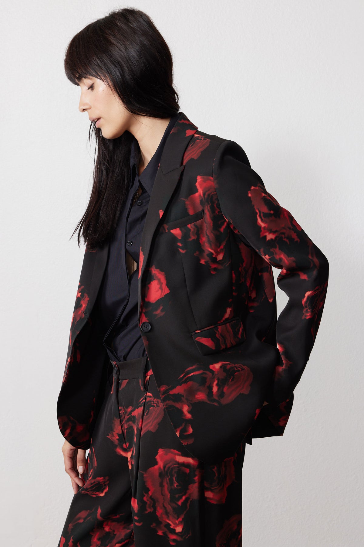 Black blazer detail with red rose print, notch lapel and button closure
