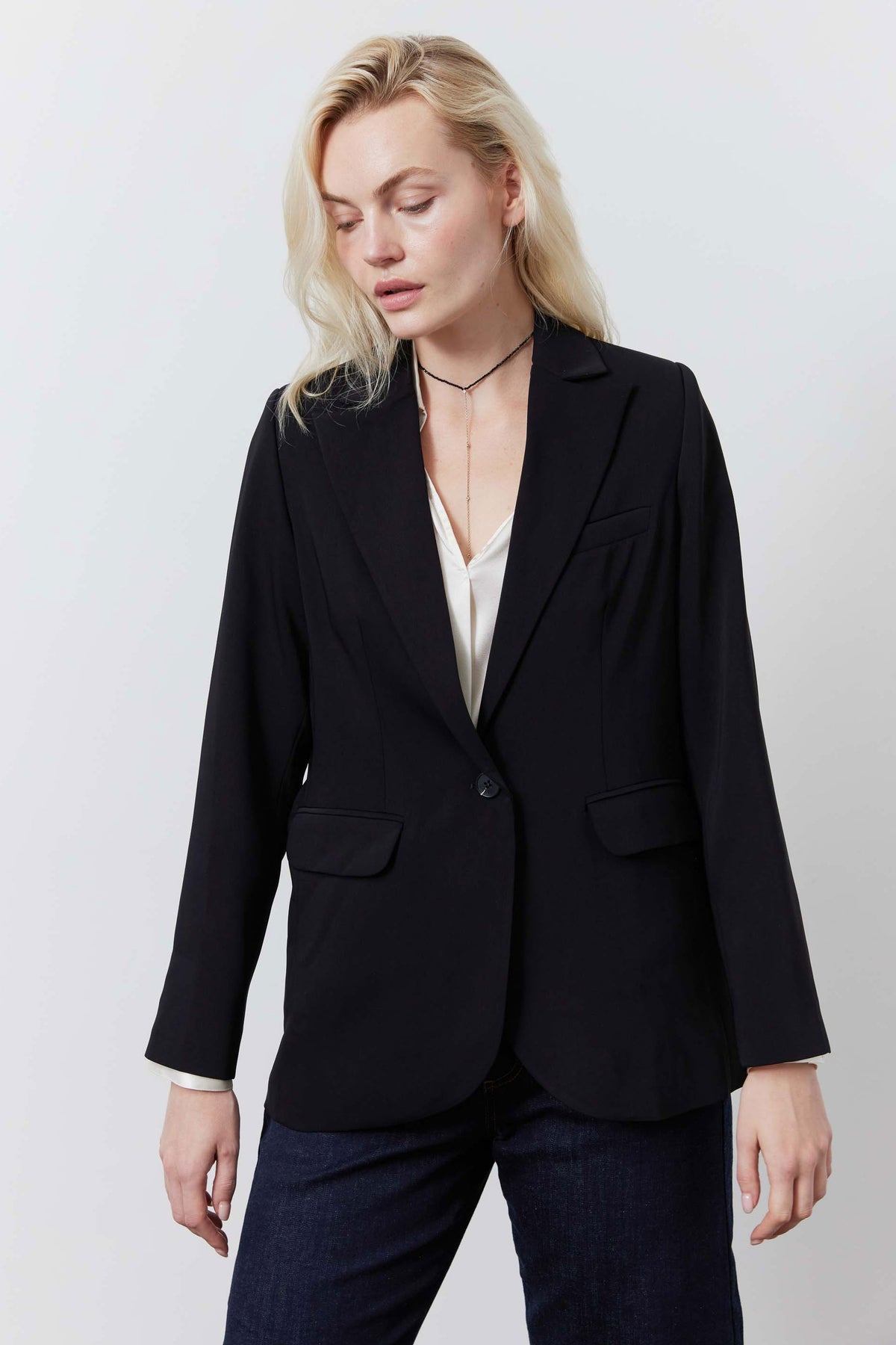Black blazer with notch lapels, button front, flap pockets, three-quarter view
