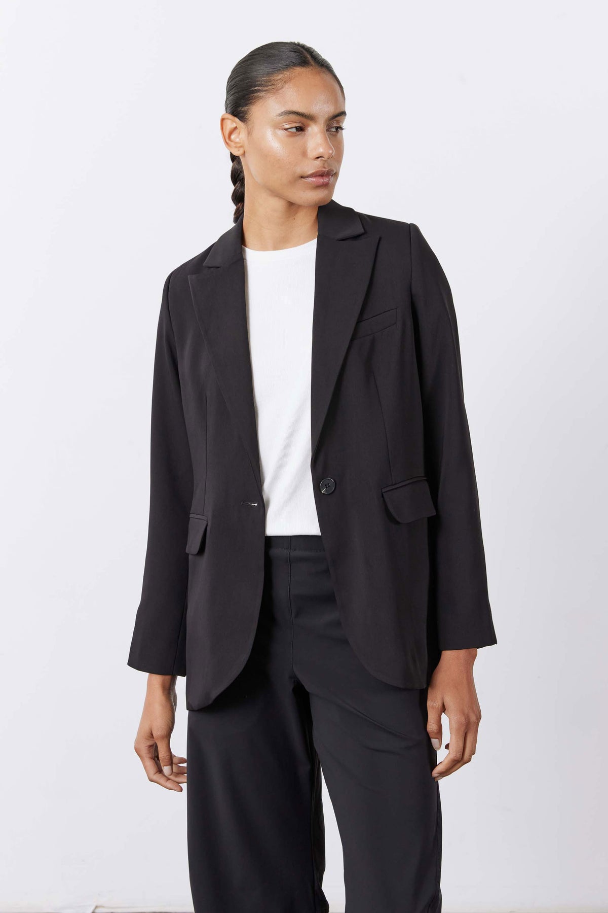 Black blazer side view with flap pockets and notch lapels, long sleeves