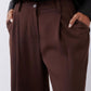 Close-up of dark brown button-front wide-leg pants with belt loops and side seam