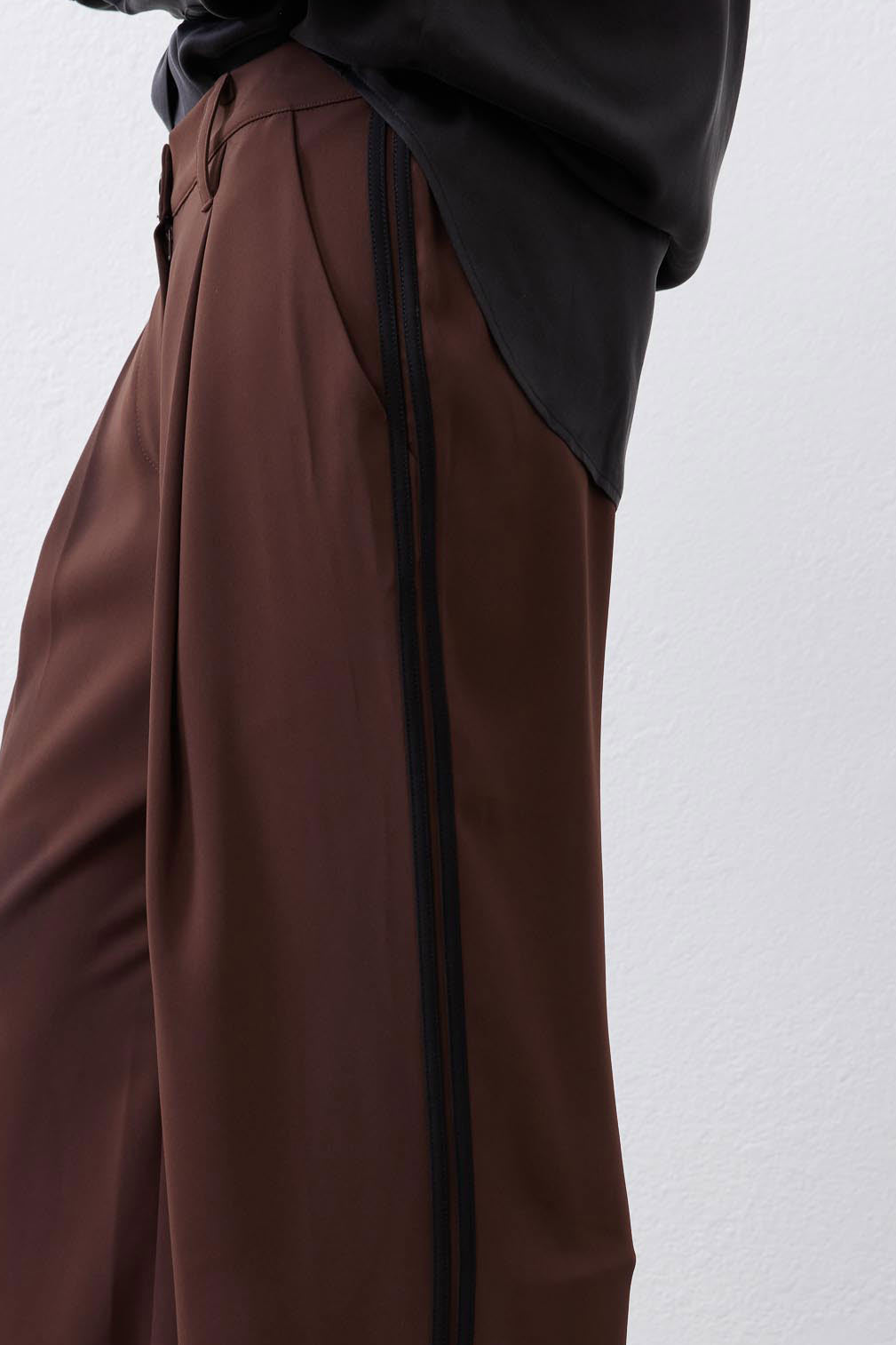 Brown wide-leg pleat pants with vertical black stripe and relaxed waist