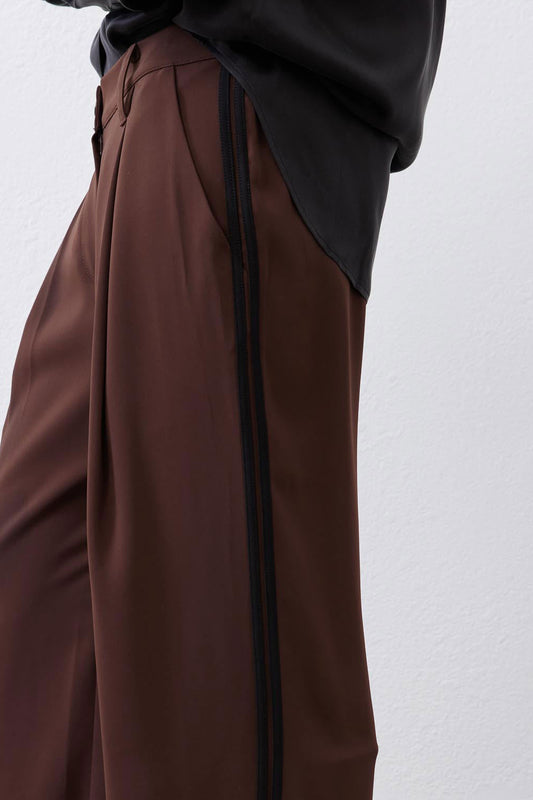 Brown wide-leg pleat pants with vertical black stripe and relaxed waist