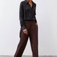 Dark brown wide-leg pleated trousers with black side stripe and button closure