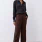 Brown wide-leg trousers with pleats, button front, and subtle black side stripe