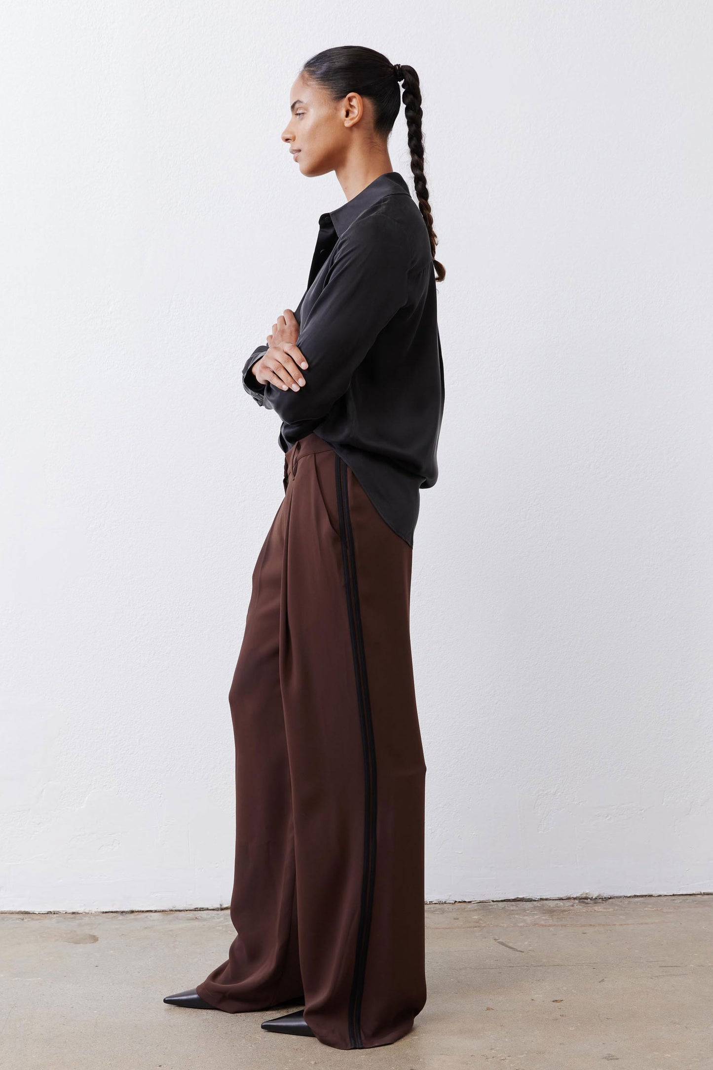 Dark brown wide-leg pants with black piping at side seams and button front