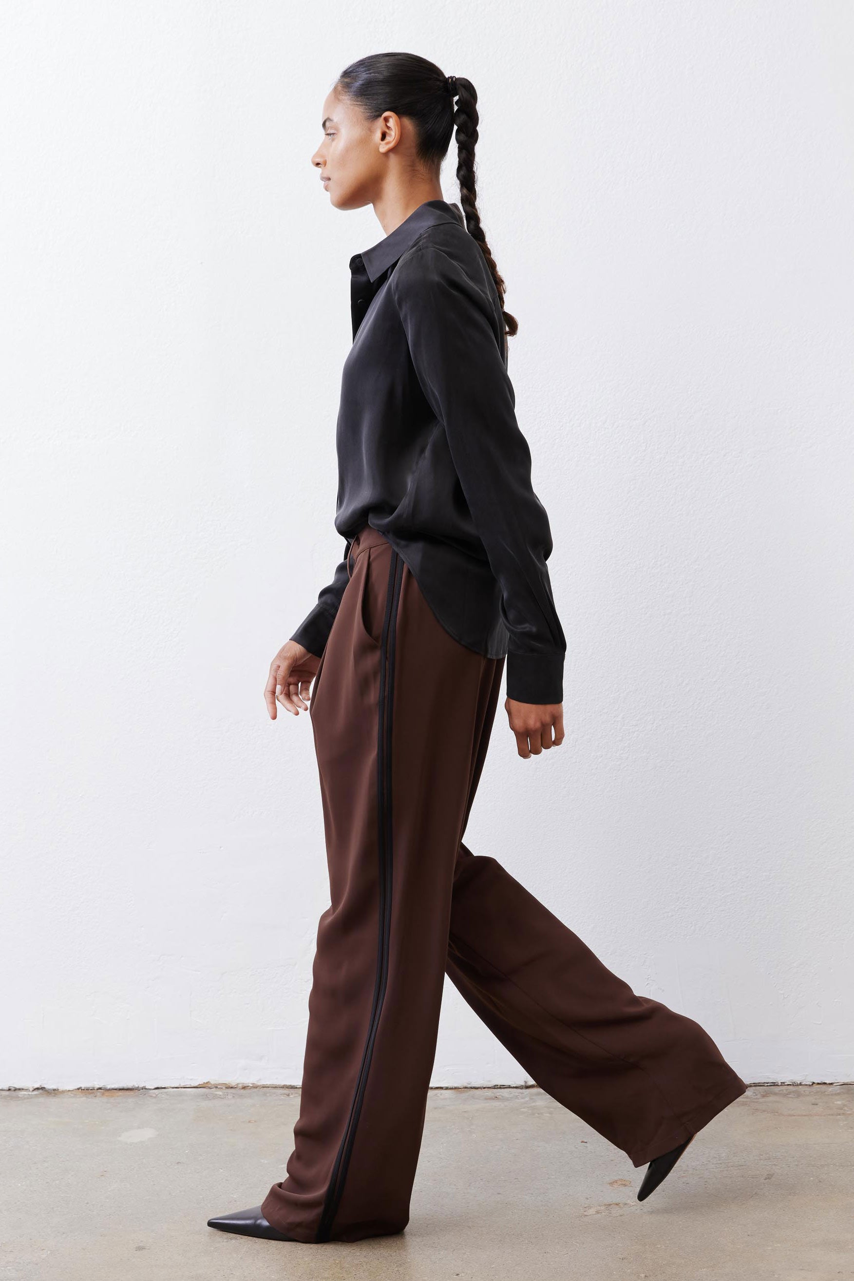 Brown wide-leg trousers with black side stripe and relaxed straight fall