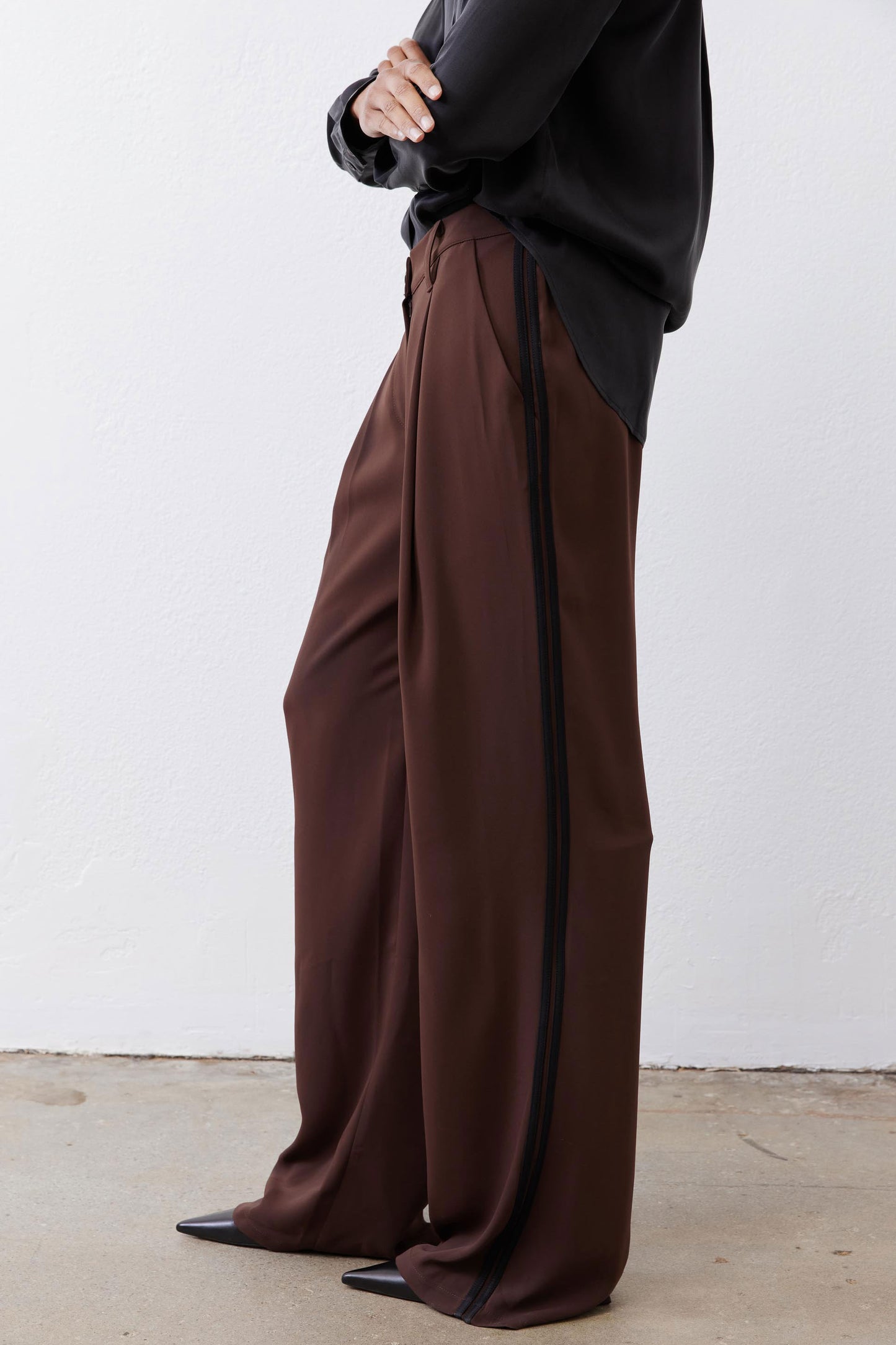 Dark brown wide-leg pants with black side stripe and long relaxed leg opening